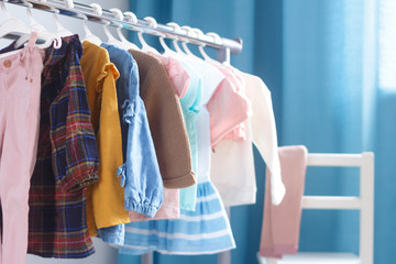 Children's cloth rack, selective focus. Pastel color children's  clothes in a Row on Open Hanger...