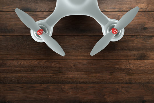 Drone, white quadrocopter on wooden, brown background with copy space. Top view, flat lay. The concept of technology, robotization, computerization. 3D render, Mixed media.