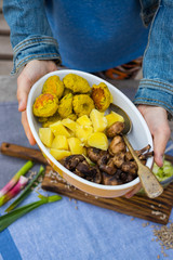 Baked vegetables in bowl. Potato, mushroms, bread, cabbage. Wooden board. On table, top view. Vegan dinner, vegetarian healthy food lunch.
