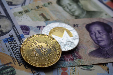 Bitcoin BTC and Monero XMR Coins on Chinese Yuan and US dollar banknotes.