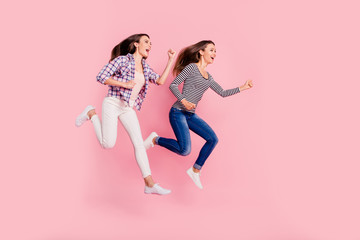 Full length body size photo of active excited teenagers teens funny funky fooling careless having stroll moving quick wearing jeans checkered blouses isolated on pink background