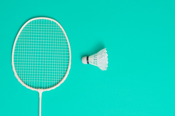 Shuttlecock and racket for playing badminton on a cyan background.