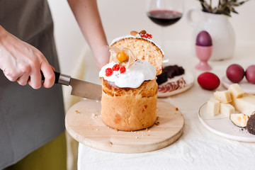 Cut easter cake in womans hand. Easter traditional orthodox sweet bread, kulich. Easter holidays breakfast. Female cutting Easter cake