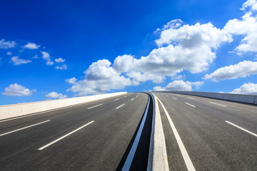 Empty asphalt road and blue sky with white clouds scene