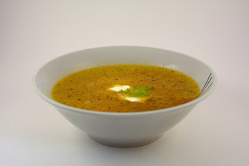 A bowl of noodle soup with sour cream on white background