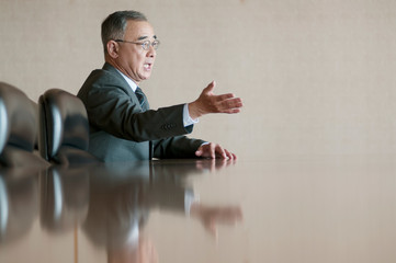 会議室で発言をするビジネスマン