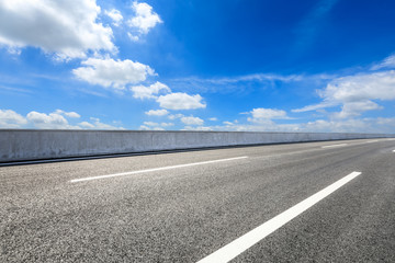 Empty asphalt road and blue sky with white clouds scene
