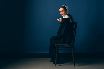Bring more colors in every day rutine. Medieval young woman as a nun in vintage clothing and white...