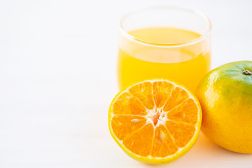 Sliced tangerine orange fruit and juice on white table