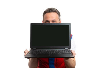 Hypermarket employee hiding face behind laptop.