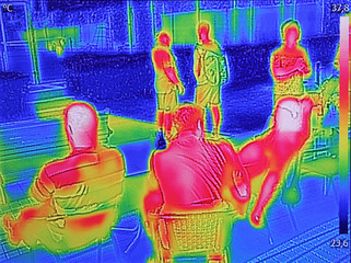 Infrared thermovision image showing when People sit at the table in the summer