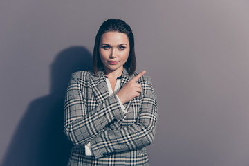 Fototapeta premium Closeup photo portrait of confident serious charming thoughtful office lady making choice pointing with forefinger looking at camera isolated grey background