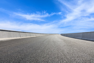 Empty asphalt road and blue sky with white clouds scene