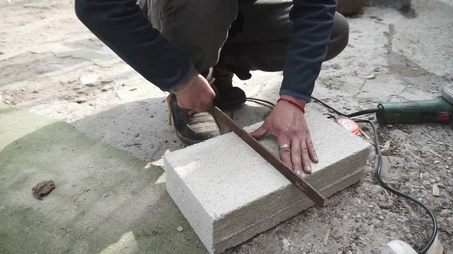 Cutting Of Concrete Close Up. Worker Uses A Stone Cutter To Cut The concrete stone.