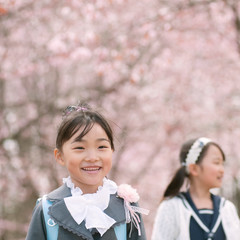 桜の前で微笑む小学生