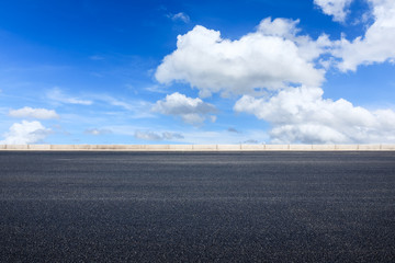 Empty asphalt road and blue sky with white clouds scene