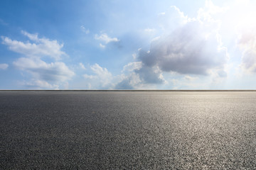 Empty asphalt road and blue sky with white clouds scene