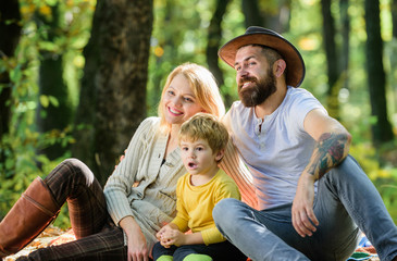 Naklejka na ściany i meble Happy son with parents relax in autumn forest. Sunny weather. Healthy food. Mother, cowboy father love their little boy child. Spring mood. Happy family day. Family picnic. Express positivity