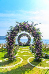 Wedding ceremony. Arch, decorated with flowers on the lawn, beach background, sea in summer. - 259698938