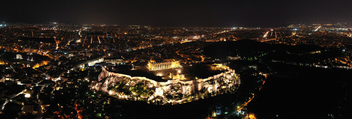 Fototapeta premium Aerial drone night shot of iconic illuminated landmark Acropolis hill and the Masterpiece of Ancient times and Western civilisation - the Parthenon, Athens historic centre, Attica, Greece