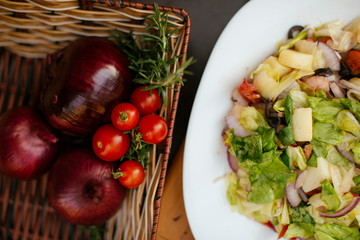 Salad in a plate with fresh vegetables and cream. 