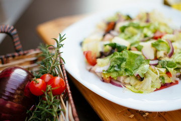 Salad in a plate with fresh vegetables and cream. 