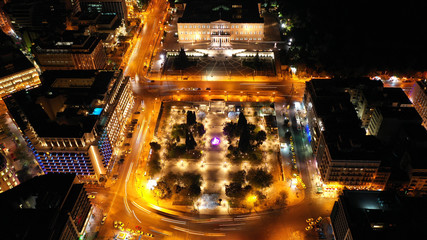 Aerial drone night shot from famous illuminated Syntagma square and Greek Parliament  building, Athens historic centre, Attica, Greece