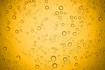 Water drops on yellow glass, Rain droplets on glass background.