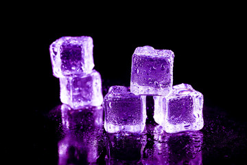 Purple ice cubes on a black table.