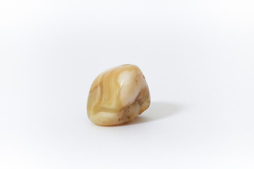 Agata gialla, primo piano di una pietra preziosa con lo sfondo bianco, oggetti da collezione