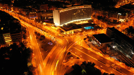 Aerial drone night shot of famous illuminated landmark hotel in centre of Athens, Attica, Greece