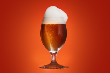 Golden beer in glass with foam, alcohol beverage,  yellow.