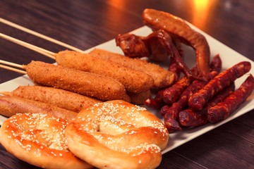 Beer glass alcohol drink with food sausage,  snack pretzel.