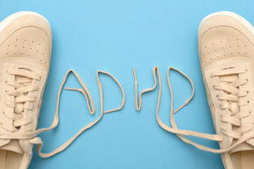 Women sneakers with laces in adhd abbreviation text. - obrazy, fototapety, plakaty
