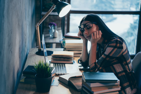 Profile side view of nice attractive smart clever intelligent brunette lady in checked shirt exhausted of hard difficult work materials pile stack at industrial loft style interior work place station