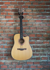 Fototapeta na wymiar Acoustic guitar with brick wall background