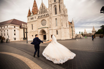 Obraz premium Young beautiful stylish pair of newlyweds walking by the Fisherman's Bastion in Budapest, Hungary
