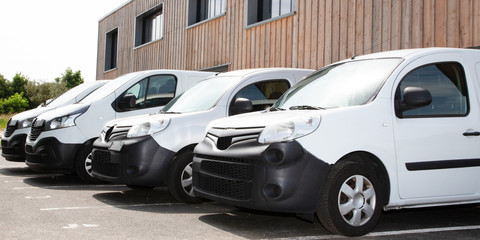 white delivery service van small trucks park front of factory warehouse distribution plant
