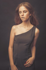 Naklejka premium Fashionable girl in golden gray tones in studio. Woman with unflappable face. Lifestyle concept in fashion world