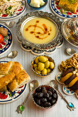 Traditional Turkish Ramadan,iftar meal table with lentil soup on the middle of table with other foods.Used Traditional Turkish Ceramic utensils and copper soup bowl together.