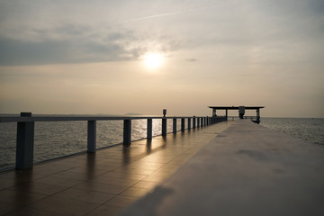 Fototapeta na wymiar Wooded bridge in the port along sunrise at island beach.