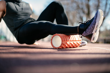 Man foam rolling. Athlete stretches using foam roller.