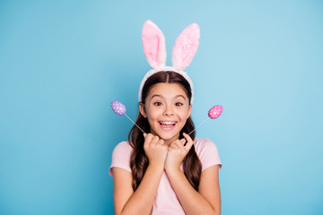 Obraz na płótnie Canvas Close up photo portrait of surprised amazed shocked with beaming teeth smile in casual t-shirt cheerful ecstatic girl holding two bright vivid easter eggs in hands isolated pastel background