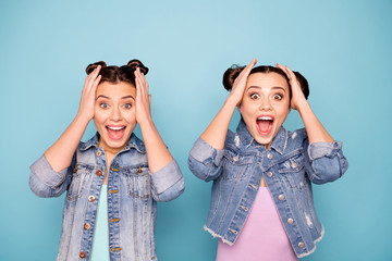 Portrait of astonished satisfied delighted ladies hearing unexpected information yelling really touching head with hands dressed in fashionable denim outfit on pastel background isolated 