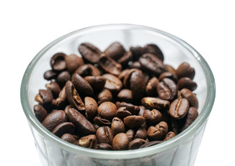 Isolated coffee beans in a glass bowl on white background.