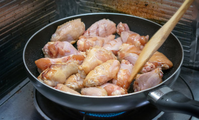 Grilling Chicken Drumsticks and Wings on a Non-Stick Coated Skillet.