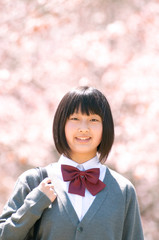桜の前で微笑む中学生