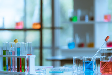 Blurred colorful test tubes at foreground.
