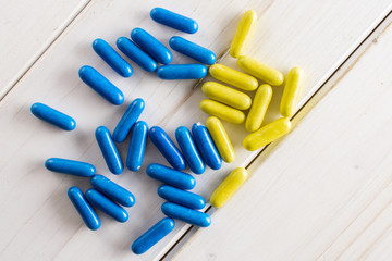 Lot of whole blue and yellow sweet licorice comfit flatlay on white wood