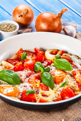 Shakshuka - fried eggs with vegetables in frying pan